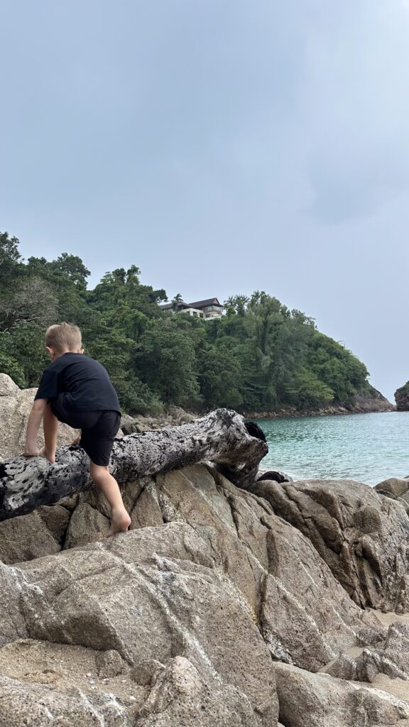 Child climbing a rock in Koh Lanta, exploring the island's natural wonders and adventurous landscapes, making it the ideal Best Island in Thailand for Families.