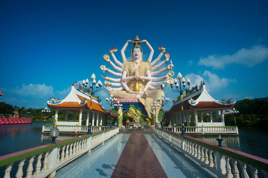 Stunning view of the Guanyin statue at Wat Plai Laem temple in Thailand, capturing its intricate design under a clear sky.